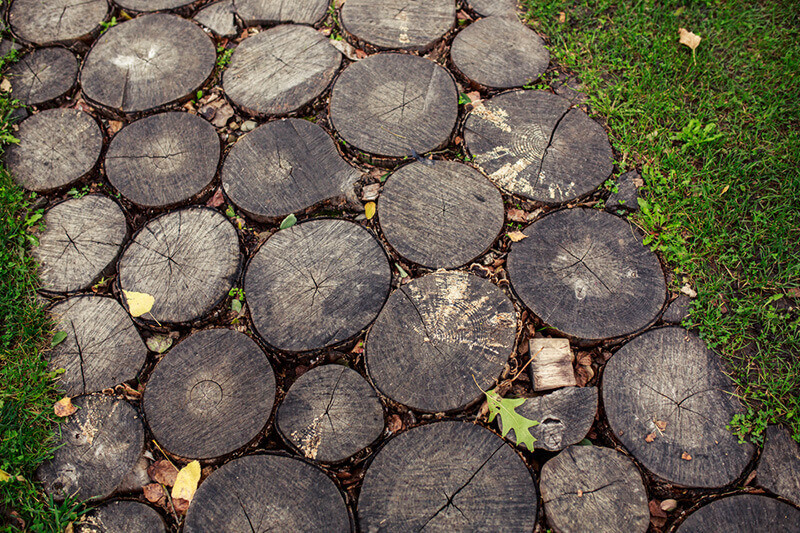 unusual outdoor walkway that's made out of circle wood slices